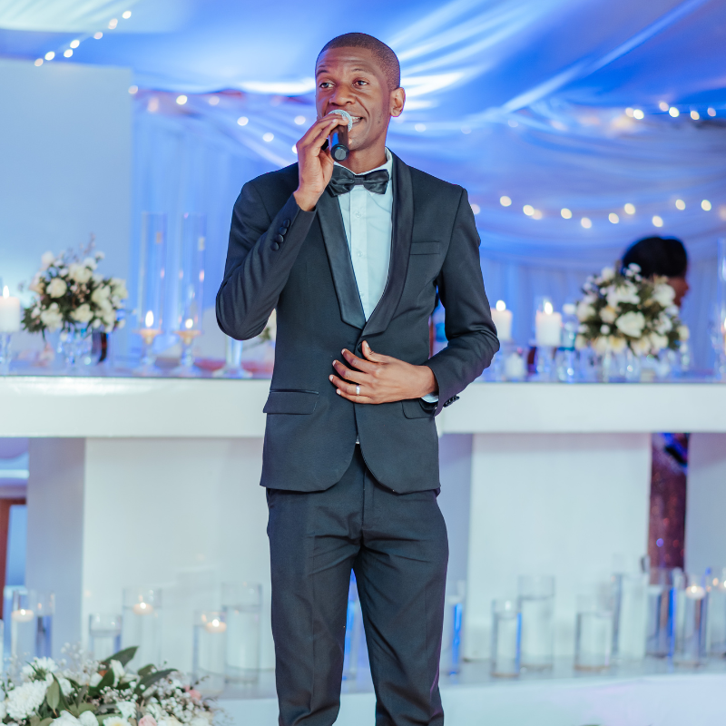 Brian MC, Harare's premier Event MC, holding a microphone and wearing a professional suit, ready to elevate your event